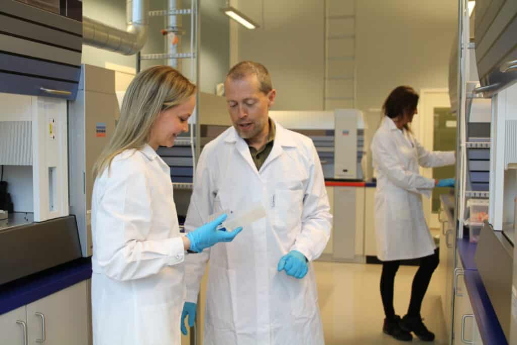 Personer som diskuterer analyseresultater på laboratoriet hos Blue Analytics.